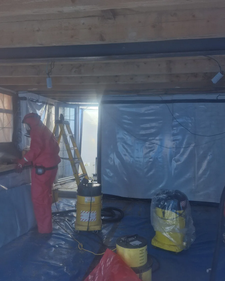 Operative working inside a sealed enclosure during commercial asbestos removal Asbestos Removal Team Ltd