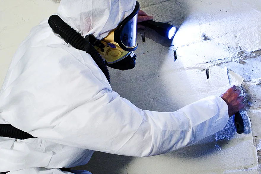 Licensed operative inspecting and sampling a suspected asbestos containing material Asbestos Removal Team Ltd